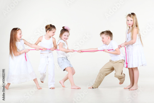 Photo: Four happy little girls and one boy draw over pink rope Four happy little girls and one boy draw over pink rope