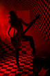 Silhouette of girl standing and playing electric guitar