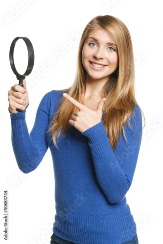 Photo: Happy female holding magnifying glass and pointing at it Happy female holding magnifying glass and pointing at it