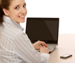 Foto: Portrait of young woman with a laptop sitting at the desk Portrait of young woman with a laptop sitting at the desk