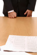 Unknown businessman standing near desk  with documents