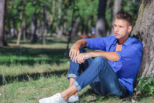 Photo: serious seated man looks away serious seated man looks away
