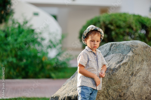 Photo: wonderful boy in a hat standing at the great stone wonderful boy in a hat standing at the great stone