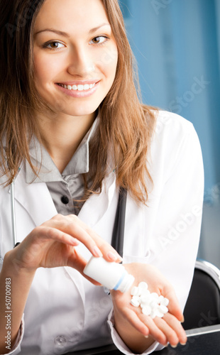Photo: Happy doctor showing bottle of drugs Happy doctor showing bottle of drugs