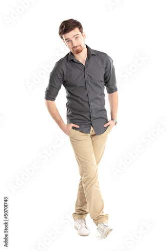 Photo: stylish young man standing with hands in pockets stylish young man standing with hands in pockets