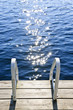 Dock on summer lake with sparkling water