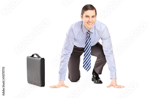 Photo: A smiling businessman with briefcase ready to run, looking at ca A smiling businessman with briefcase ready to run, looking at ca
