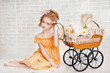 Girl in orange dress with vintage pram