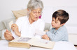 Foto: Enkel und Oma schauen ein Fotoalbum an Enkel und Oma schauen ein Fotoalbum an