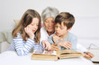 Foto: Kinder und Oma schauen ein Fotoalbum an Kinder und Oma schauen ein Fotoalbum an