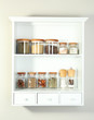 Beautiful white shelves with spices in glass bottles