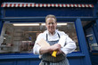 Photo: Portrait of a happy senior butcher standing with crossed cleavers in hands outside shop Portrait of a happy senior butcher standing with crossed cleavers in hands outside shop