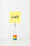 Photo: Sticky notepaper with French text meaning "Lait" (milk) clipped to a multicolored card holder Sticky notepaper with French text meaning "Lait" (milk) clipped to a multicolored card holder