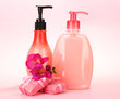 Liquid and hand-made soaps on pink background