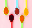 Baby puree in spoons on pink background