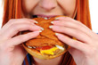 Young woman eating hamburger