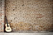 chitarra poggiata su muro di mattoni