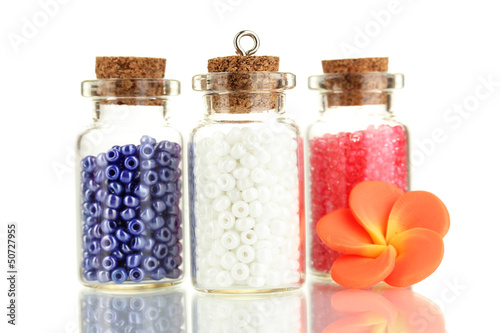 Photo: Little bottles full with colorful beads isolated on white Little bottles full with colorful beads isolated on white