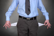 Business man showing his empty pockets, on grey background