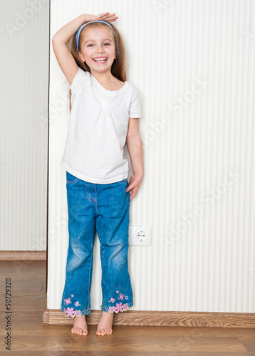 Photo: little girl measures the growth little girl measures the growth