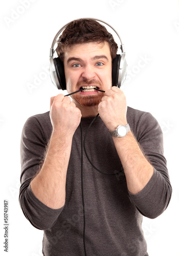Photo: young man listening to music and biting a wire young man listening to music and biting a wire