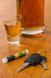 Schnapsglas mit Autoschlüssel und Alkoholtester