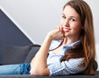 Attraktive junge Frau sitzt entspannt auf der Couch