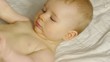 HD1080p Baby laying on a blanket puts her foot in her mouth