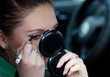 The girl is doing makeup in the car