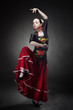 Foto: young woman dancing flamenco with castanets on black young woman dancing flamenco with castanets on black