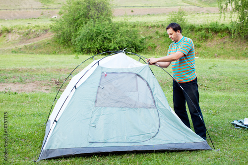 Photo: A man puts a tent A man puts a tent