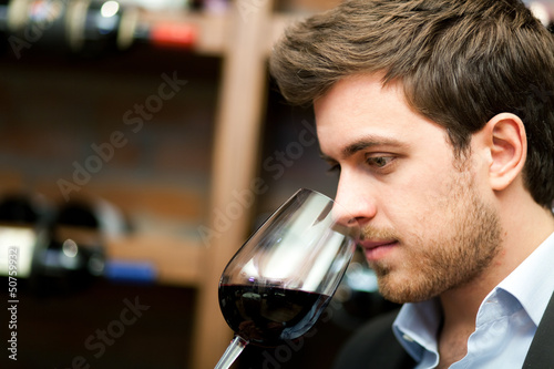 Photo: Man tasting a glass of red wine Man tasting a glass of red wine