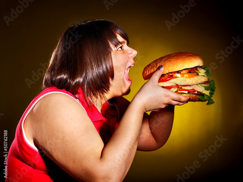 Photo: Woman eating hamburger. Woman eating hamburger.