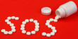 word SOS made of pills.