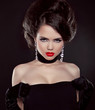 Portrait of beautiful brunette woman with red lips over dark