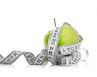 Measuring tape wrapped around a green apple