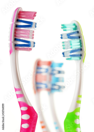 Photo: Composition with toothbrushes isolated on white Composition with toothbrushes isolated on white