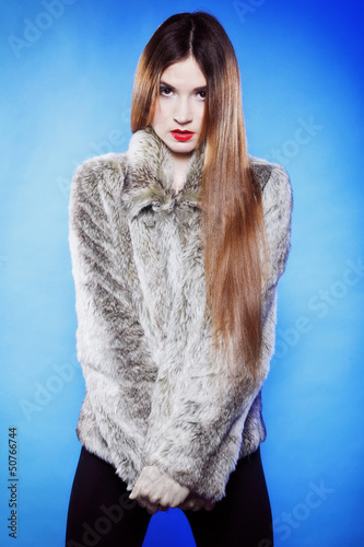 Photo: portrait of young woman in fur blue background portrait of young woman in fur blue background