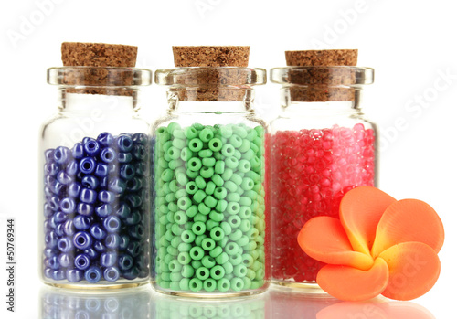 Photo: Little bottles full with colorful beads isolated on white Little bottles full with colorful beads isolated on white