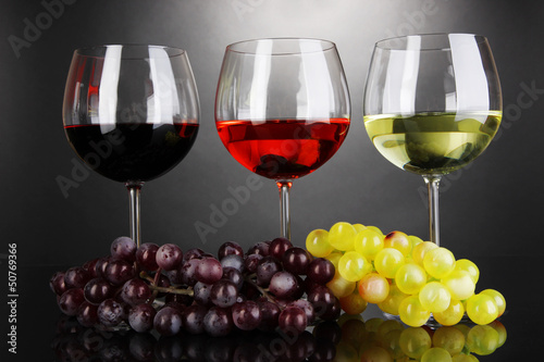 Photo: Assortment of wine in glasses on grey background Assortment of wine in glasses on grey background