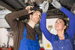 KfZ Mechatroniker reparieren reparieren Fahrzeug auf Hebebühne