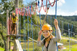 Woman climbing on rope ladder adrenalin park