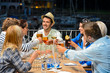 Young friends clinking glasses night restaurant
