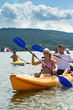Smiling couple rowing kayak sunshine