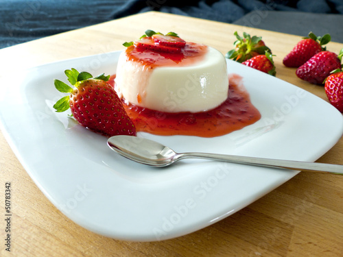 Photo: Panna Cotta auf einem Teller und Holzbrett Panna Cotta auf einem Teller und Holzbrett