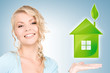 woman holding green house in her hands