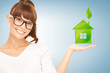 woman holding green house in her hands