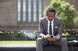 Photo: Portrait of African American Businessman listening to music with headphones outdoors Portrait of African American Businessman listening to music with headphones outdoors