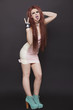 Photo: Portrait of funky woman sticking out tongue and making rebellious gestures over black background Portrait of funky woman sticking out tongue and making rebellious gestures over black background