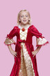 Foto: Portrait of a happy young girl dressed in princess costume over pink background Portrait of a happy young girl dressed in princess costume over pink background